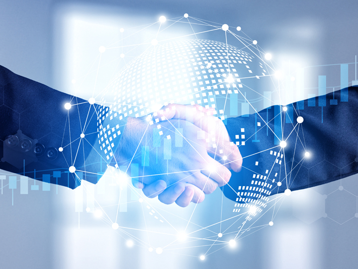 Two businesspeople shake hands over a digital globe and network lines, symbolizing global tech partnership and collaboration.